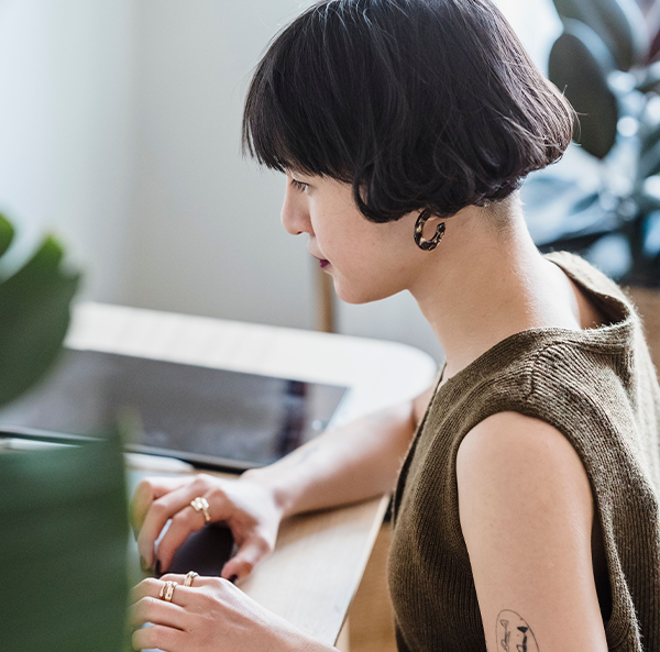 Team member working at a computer, managing multilingual content for a TRIMIT e-commerce site.